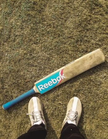 Photo by Shivansh Singh a baseball bat laying on the ground next to a person's feet